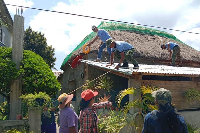 <p>Police help residents reinforce the roof of their homes in Ivana town, Batanes province, on the very tip of the Philippines</p>
