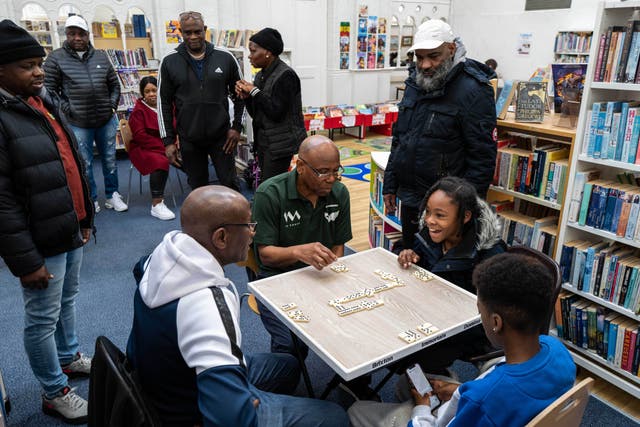 The Brixton Immortals Domino Club teaching the young generation how to play the game as part of a collaboration with Lambeth Libraries (Windrush: A Voyage through the Generations/Jim Grover/PA)