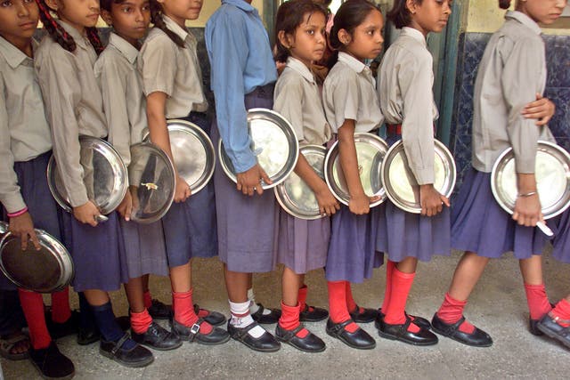 <p>File image: Students wait in a queue to get their lunches in India </p>