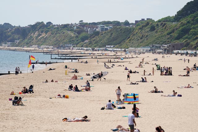 <p>People enjoy the warm weather on Bournemouth beach in Dorset</p>