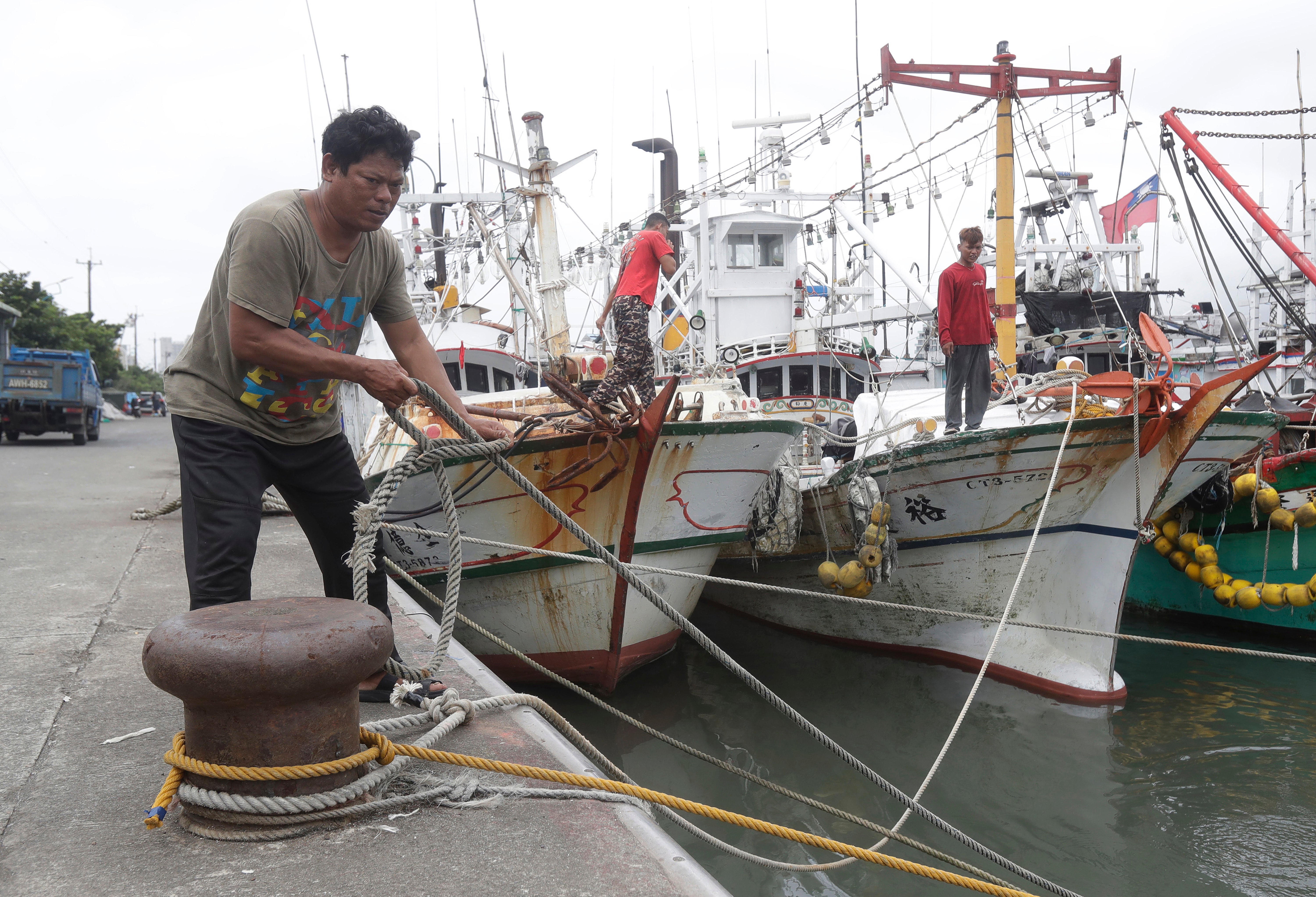 Fishermen fasten the boats as Typhoon Mawar approaches to Taiwan in Yilan County