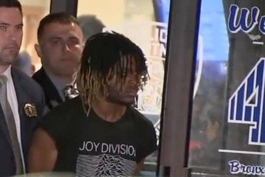 Damion Comager in handcuffs after he was charged with murder