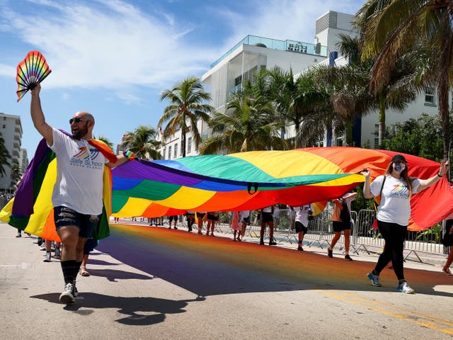 <p>People carry the Rainbow Flag as they participate in the Miami Beach Pride Parade along Ocean Drive on September 19, 2021 in Miami Beach, Florida</p>