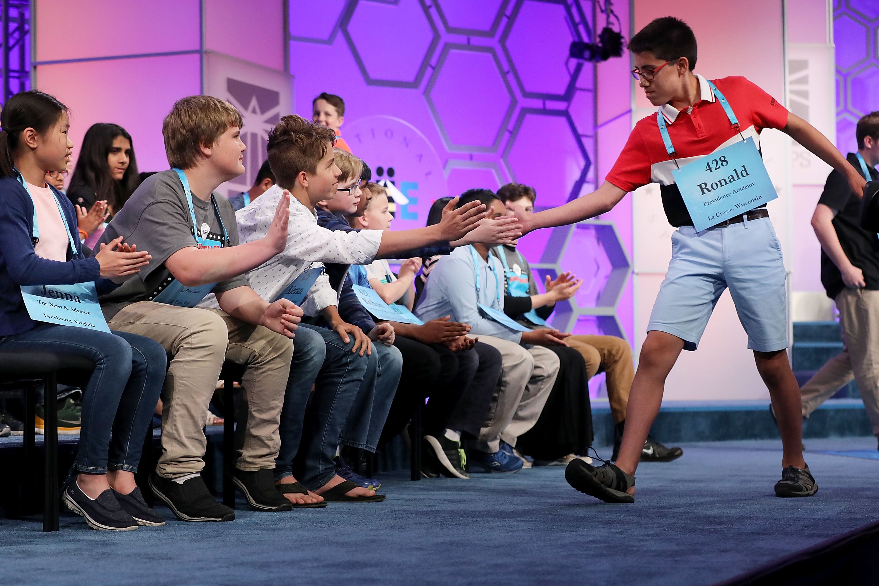 Ronald Walters of Onalaska, Wisconsin, is high-fived by his fellow competitors during the third round of 2018 Scripps National Spelling Bee