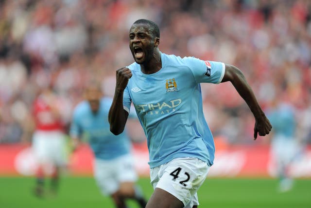 <p>Yaya Toure of Manchester City celebrates scoring against Manchester United in 2011</p>