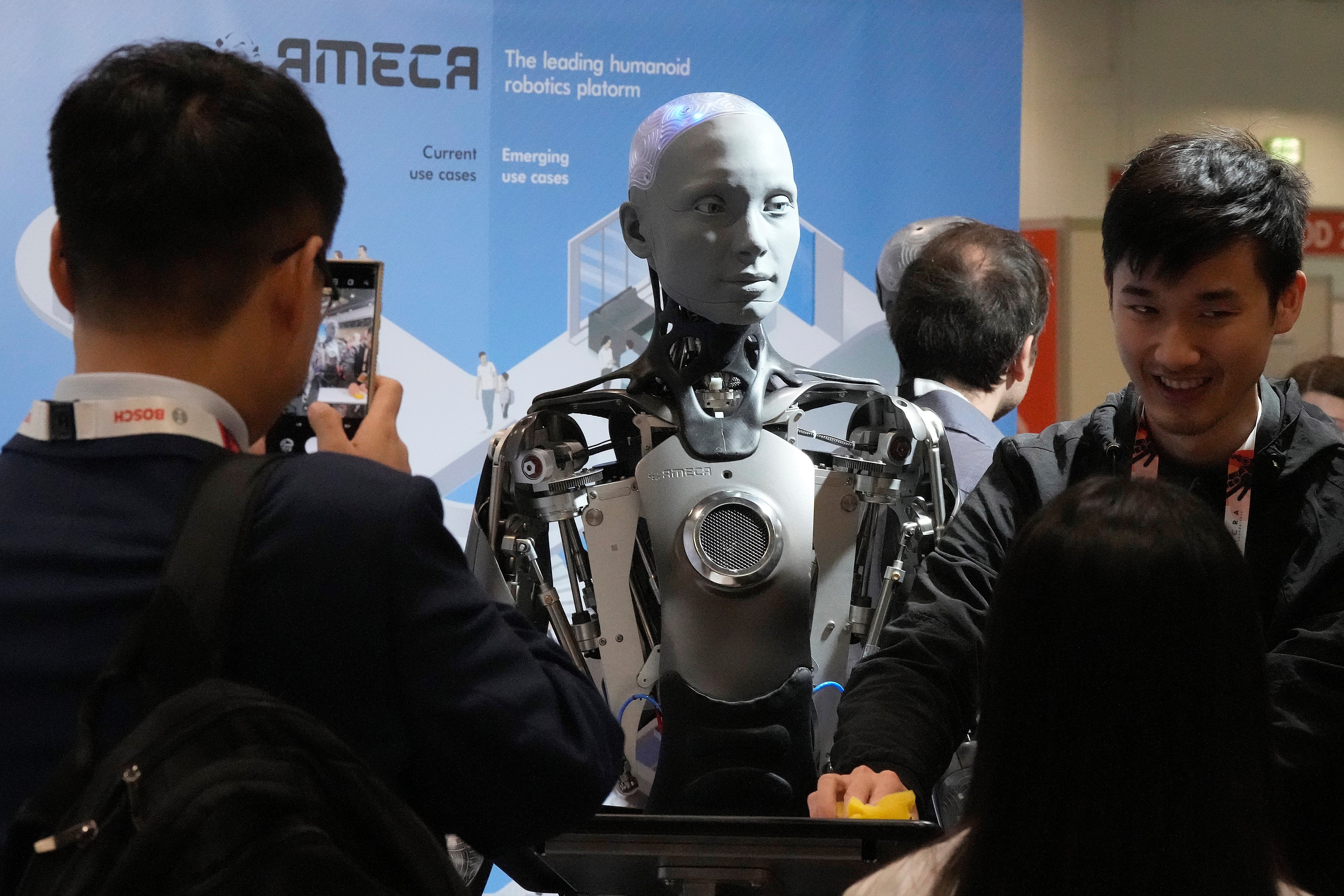 A robot designed by Engineers Arts and called Ameca, interacts with visitors during the International Conference on Robotics and Automation ICRA (Frank Augstein/AP)
