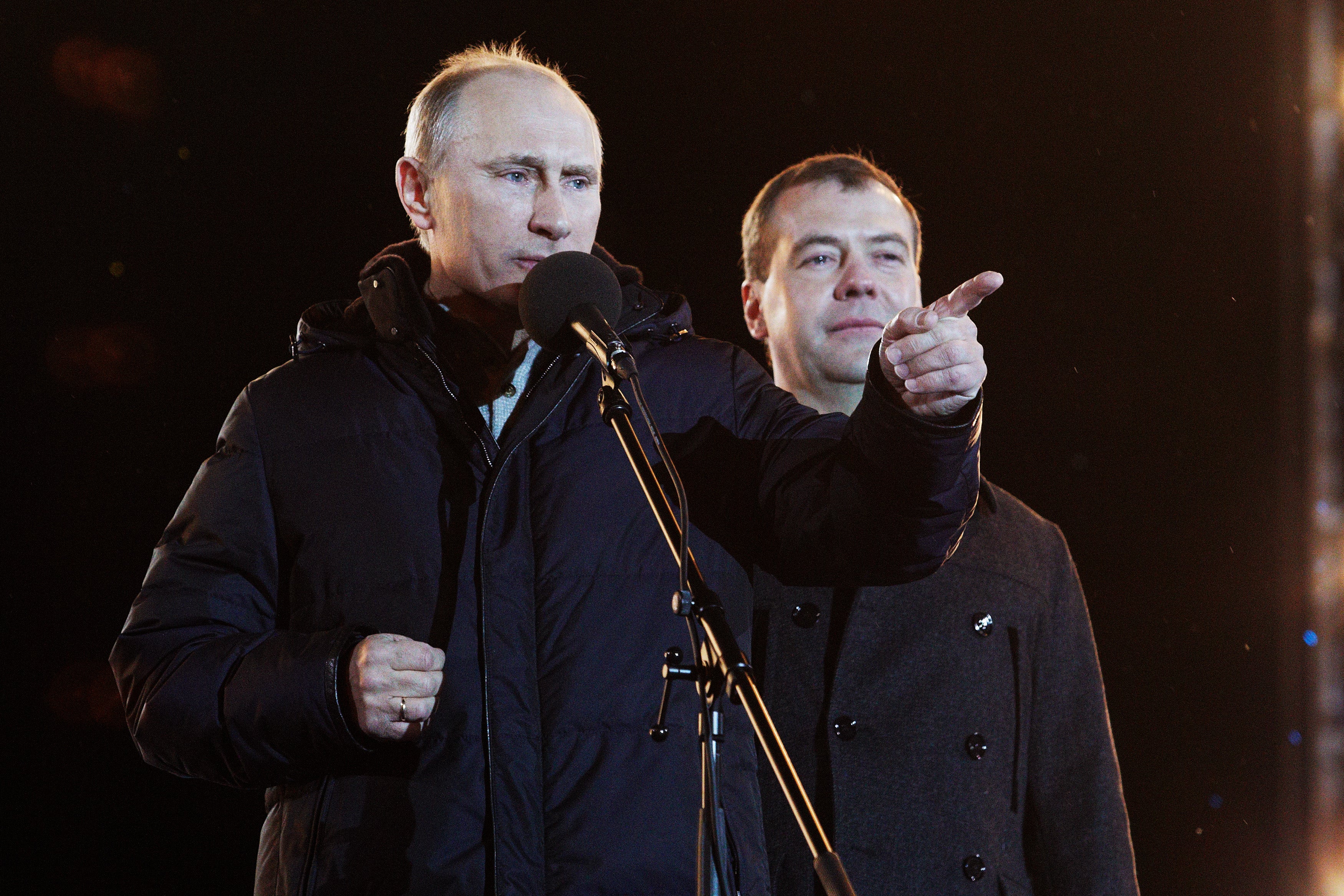 File: Russian president Vladimir Putin speaks as Dmitry Medvedev (R) listens during a rally after Putin claimed victory in the presidential election in Moscow in 2012