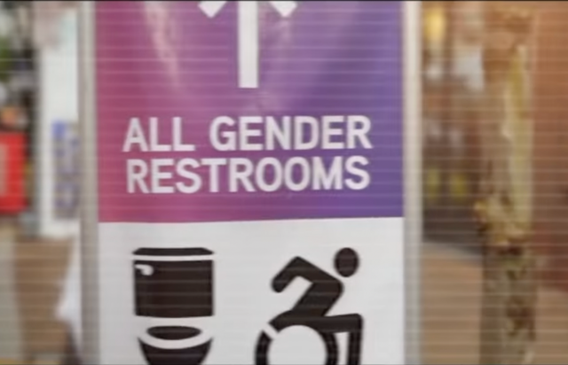 <p>An image from a Donald Trump campaign advertisement showing a sign for all-gender restrooms</p>
