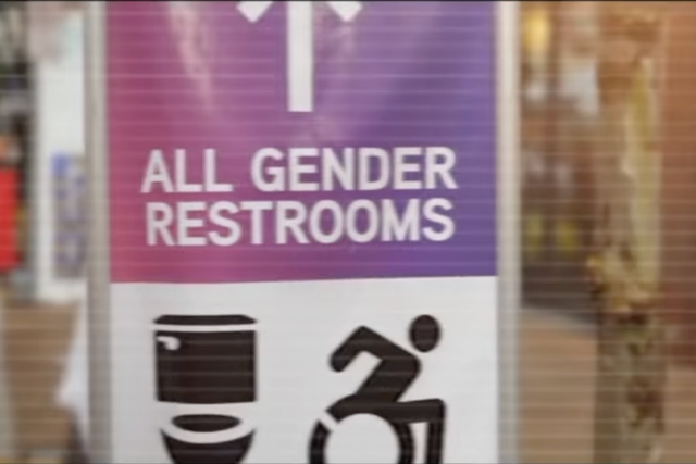 <p>An image from a Donald Trump campaign advertisement showing a sign for all-gender restrooms</p>