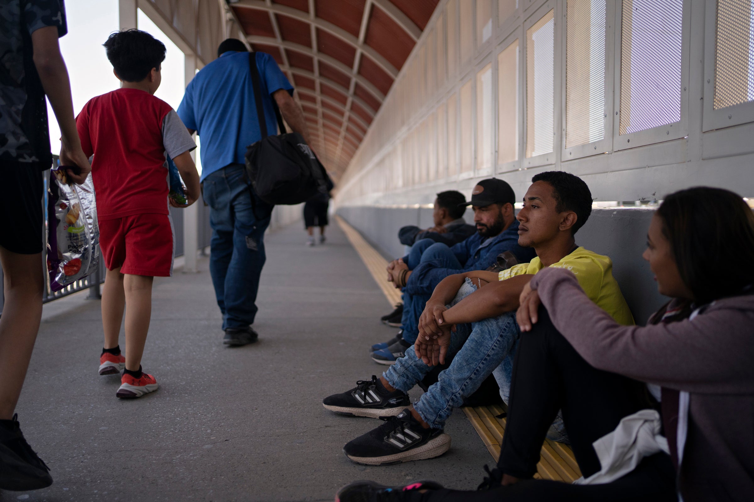 Migrants from Brazil sit on the Ysleta-Zaragoza Bridge connecting Juárez and El Paso on 13 May, hoping to seek asylum in the United States