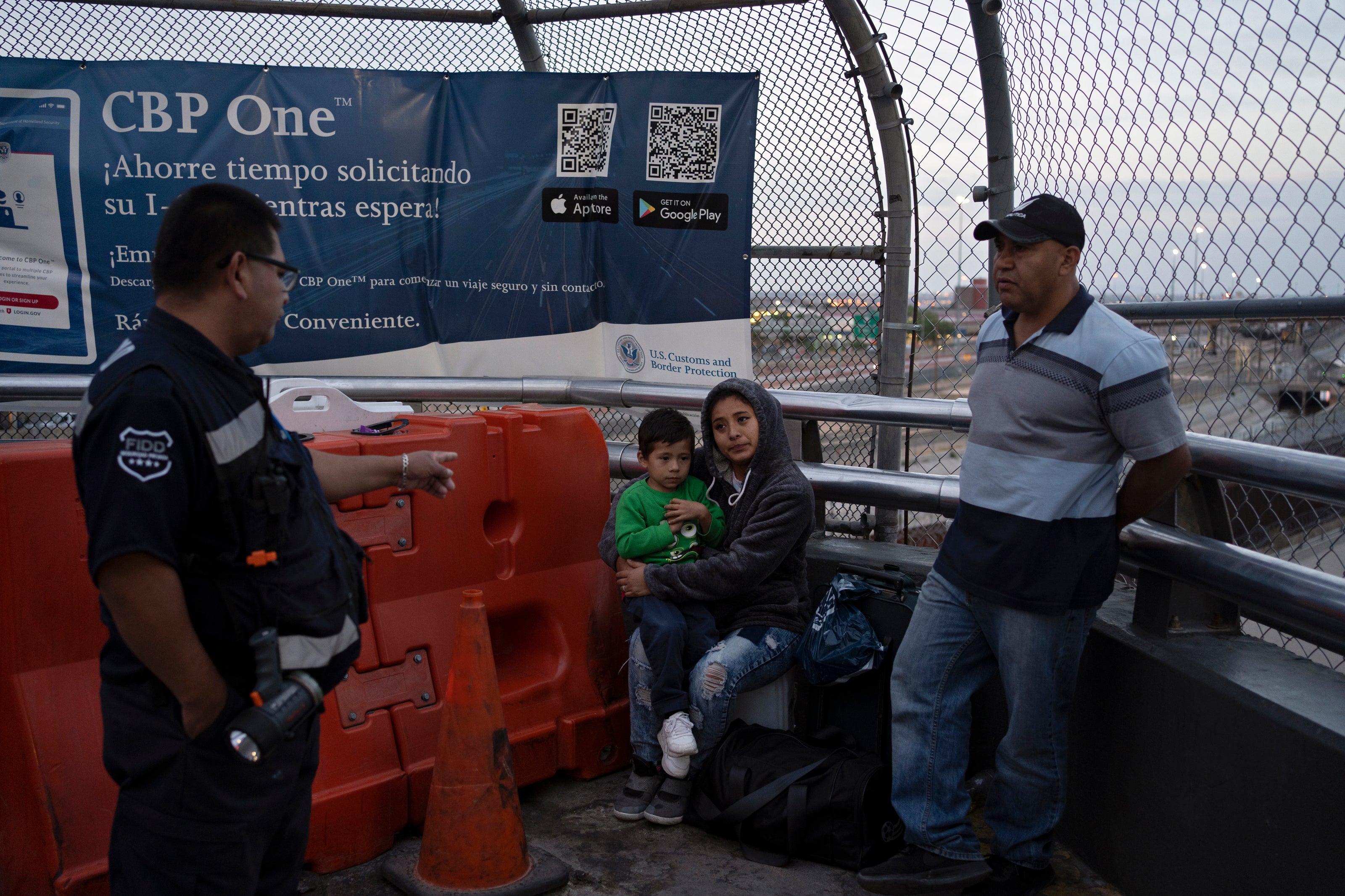 A Mexican security officer urges the Callejas family to wait at the entrance of the Paseo del Norte International Bridge, instead of where they were seated