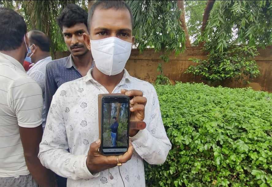 Bhuddhadev Mandol, a neighbour of Rajib Dakua, shows his picture to the press