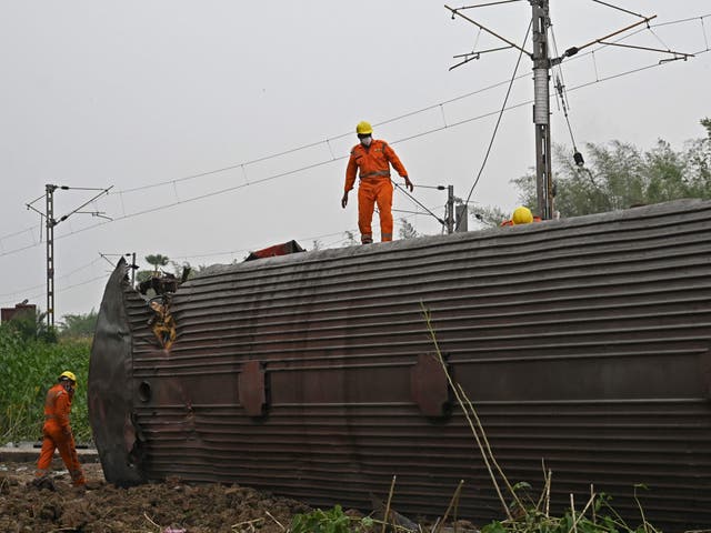 <p>Rescue workers inspect an overturned carriage after the worst train disaster in India this century  </p>