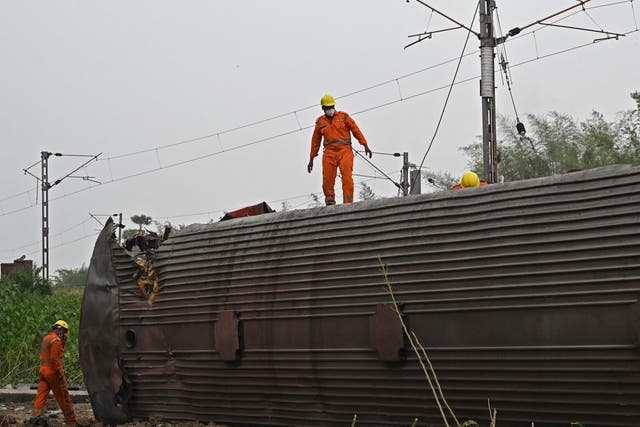 <p>Rescue workers inspect an overturned carriage after the worst train disaster in India this century  </p>
