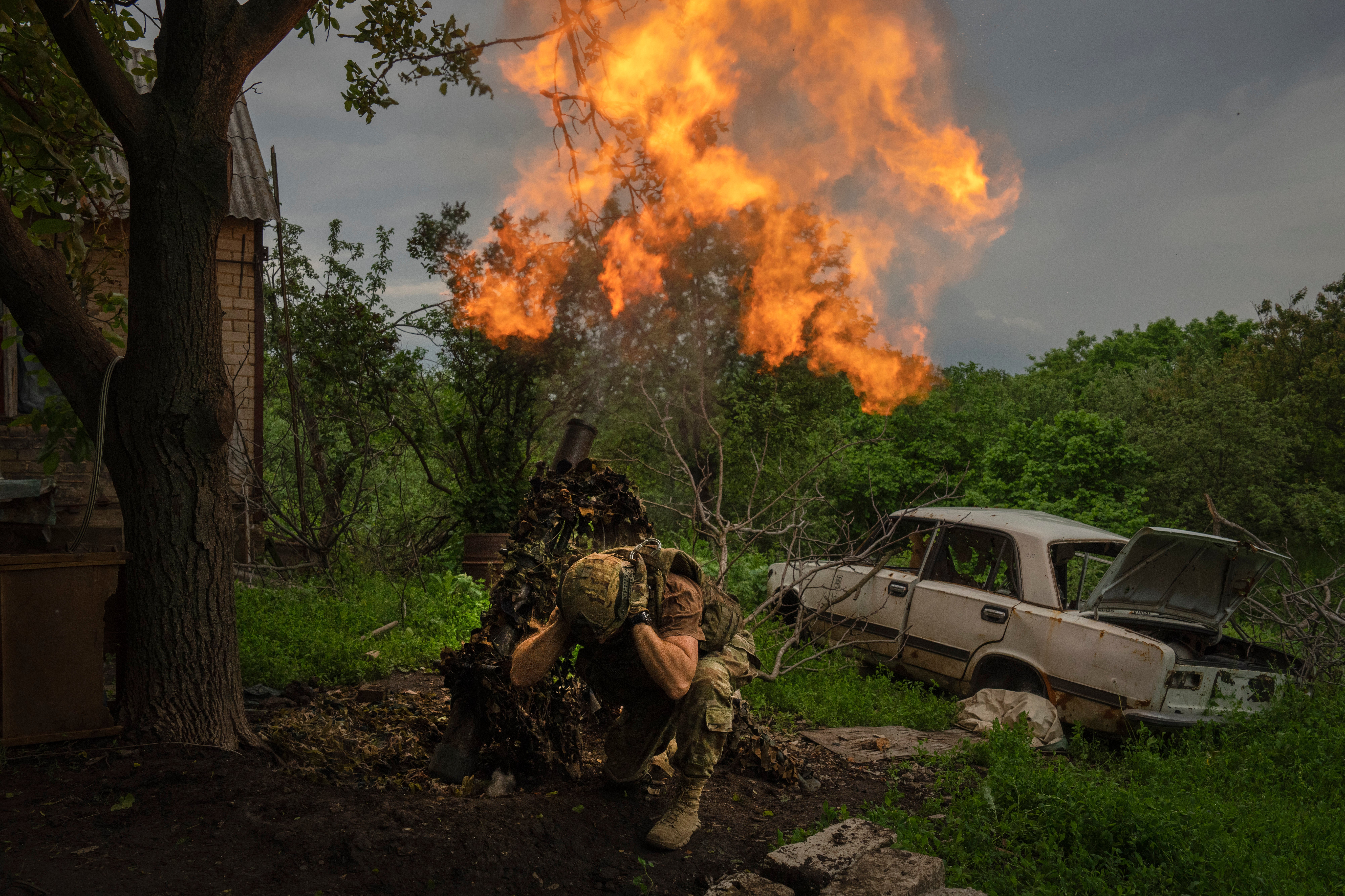 A Ukrainian soldier fires a mortar at Russian positions on the frontline in Donetsk