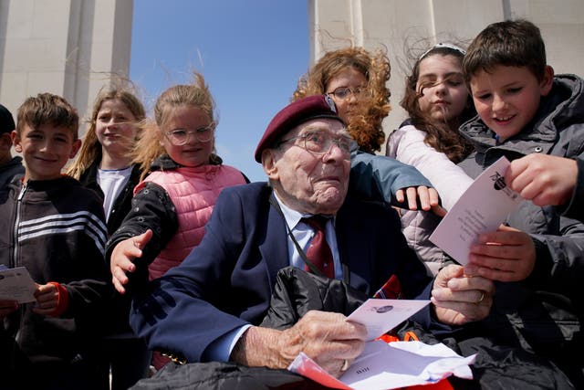 D-Day veteran Bill Gladden, 6th Airborne Army Recce Regiment RAC, meets French schoolchildren at the British Normandy Memorial at Ver-sur-Mer (Gareth Fuller/PA)