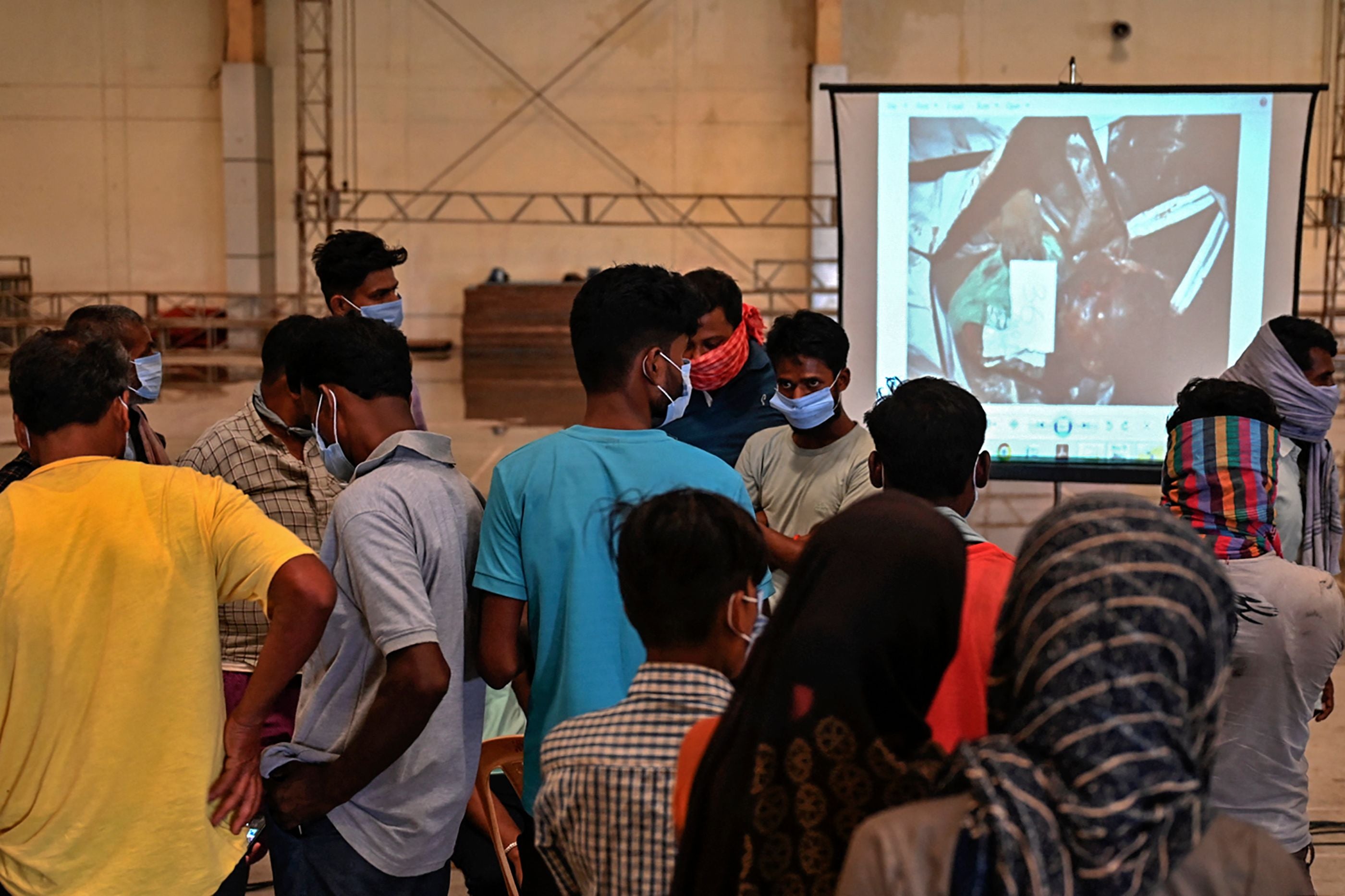 Large television screens show pictures of unidentified bodies for family members to assist in identifcation
