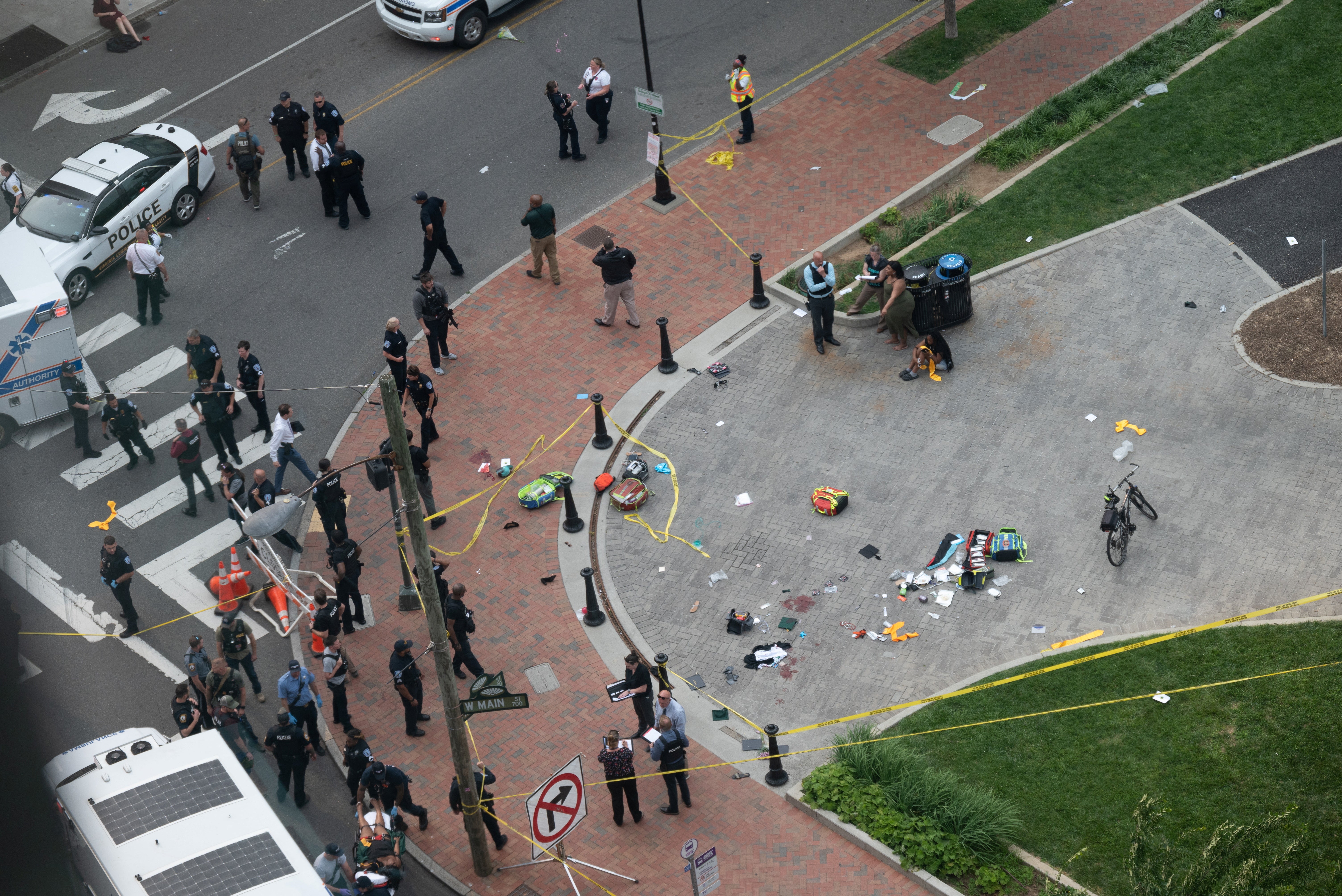 Law enforcement officers investigate at the scene after a gunman opened fire in a park as high school graduates and their families emerged from a theater where commencement exercises had just concluded, in Richmond, Virginia