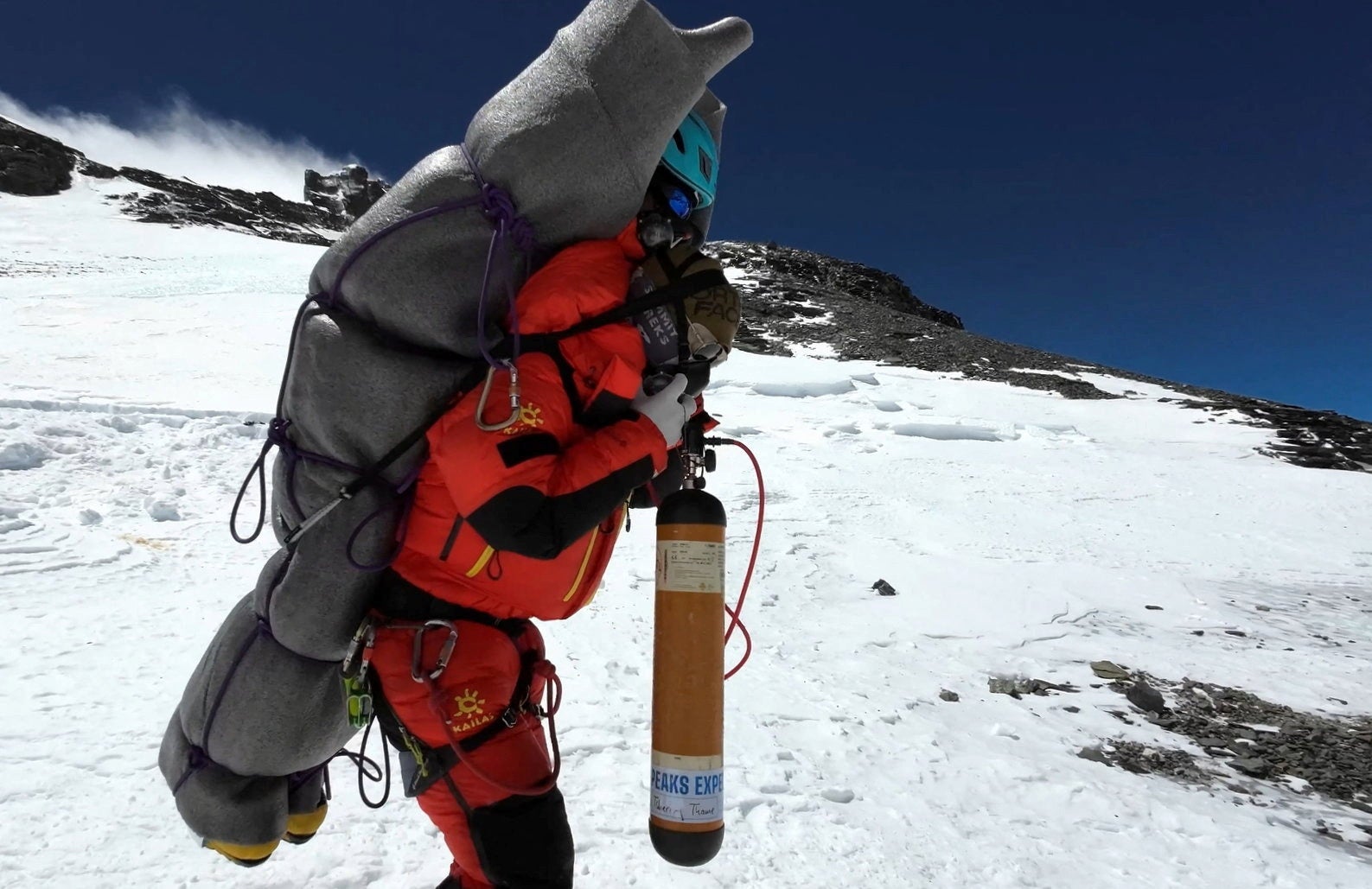 Ngima Tashi Sherpa walks as he carries a Malaysian climber while rescuing him from the death zone above camp four at Everest, Nepal, 18 May 2023 in this screengrab obtained from a handout video