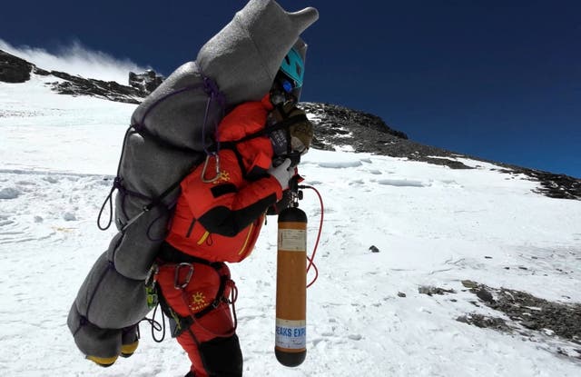 <p>Ngima Tashi Sherpa walks as he carries a Malaysian climber while rescuing him from the death zone above camp four at Everest, Nepal, 18 May  2023 in this screengrab obtained from a handout video</p>