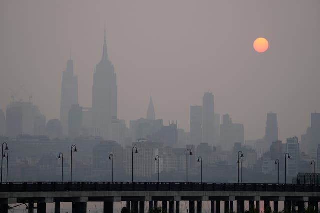 El sol sale sobre un horizonte brumoso de la ciudad de Nueva York visto desde la ciudad de Jersey el miércoles
