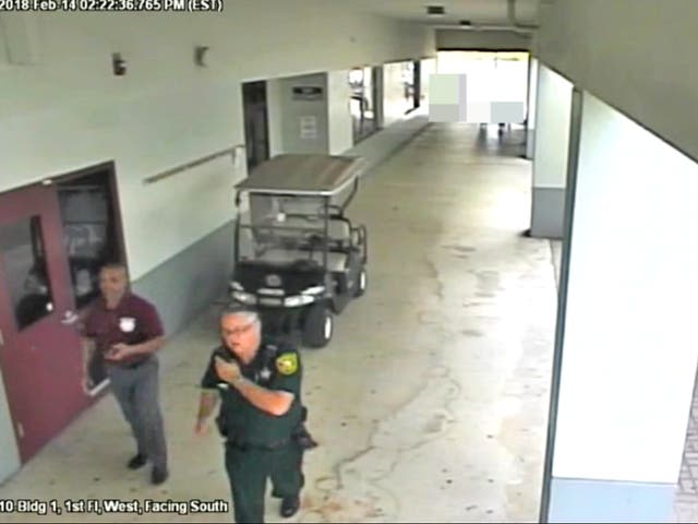 <p>Former Broward County deputy Scot Peterson walking with an unarmed security guard outside Marjorie Stoneman Douglas High School during the Parkland mass shooting</p>