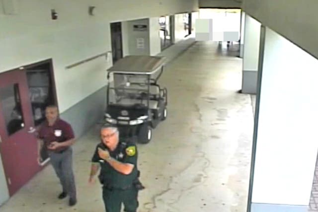 <p>Former Broward County deputy Scot Peterson walking with an unarmed security guard outside Marjorie Stoneman Douglas High School during the Parkland mass shooting</p>