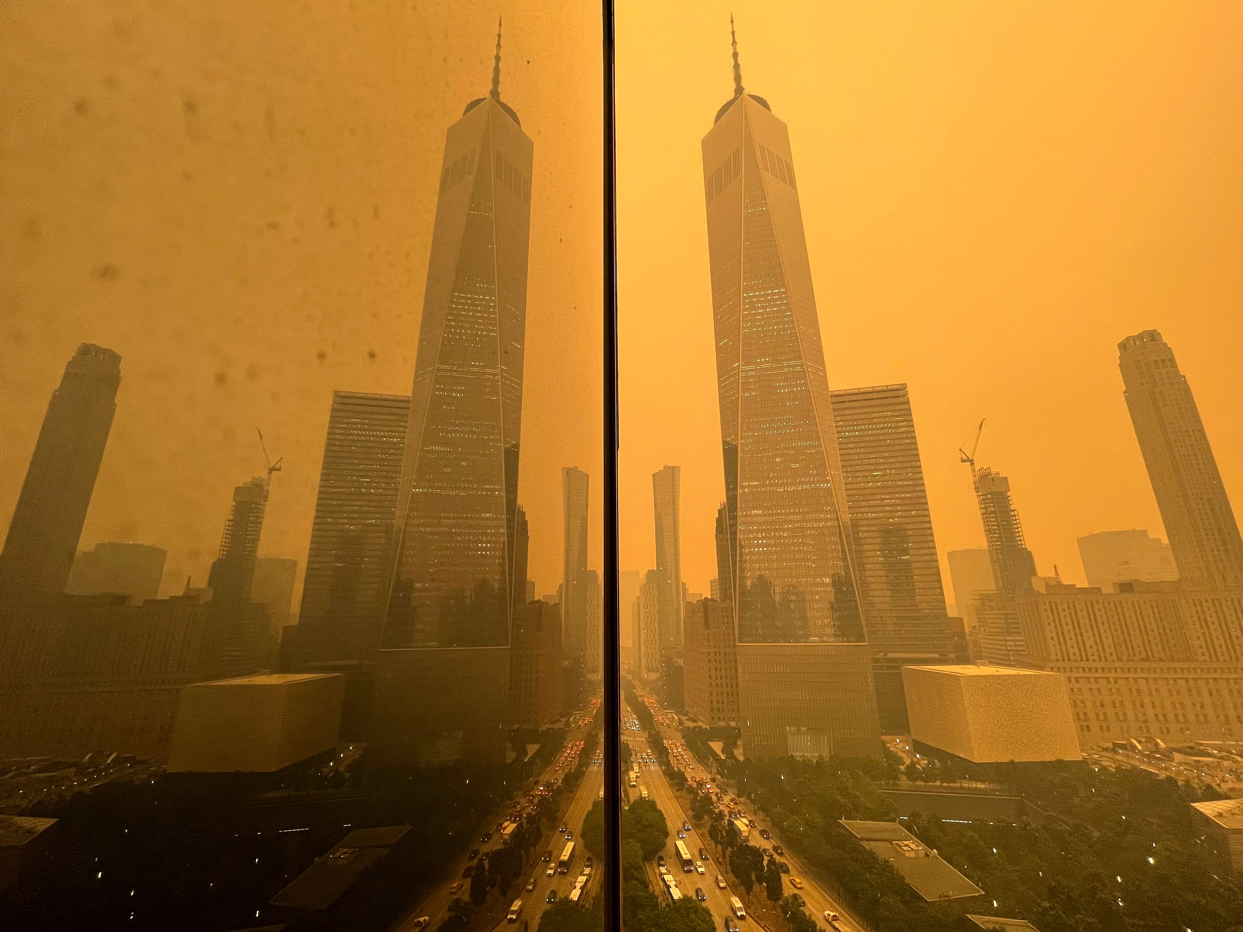 Traffic moves along West Street past One World Trade Center, in this mirror image reflected in the facade of a building, Wednesday, June 7, 2023