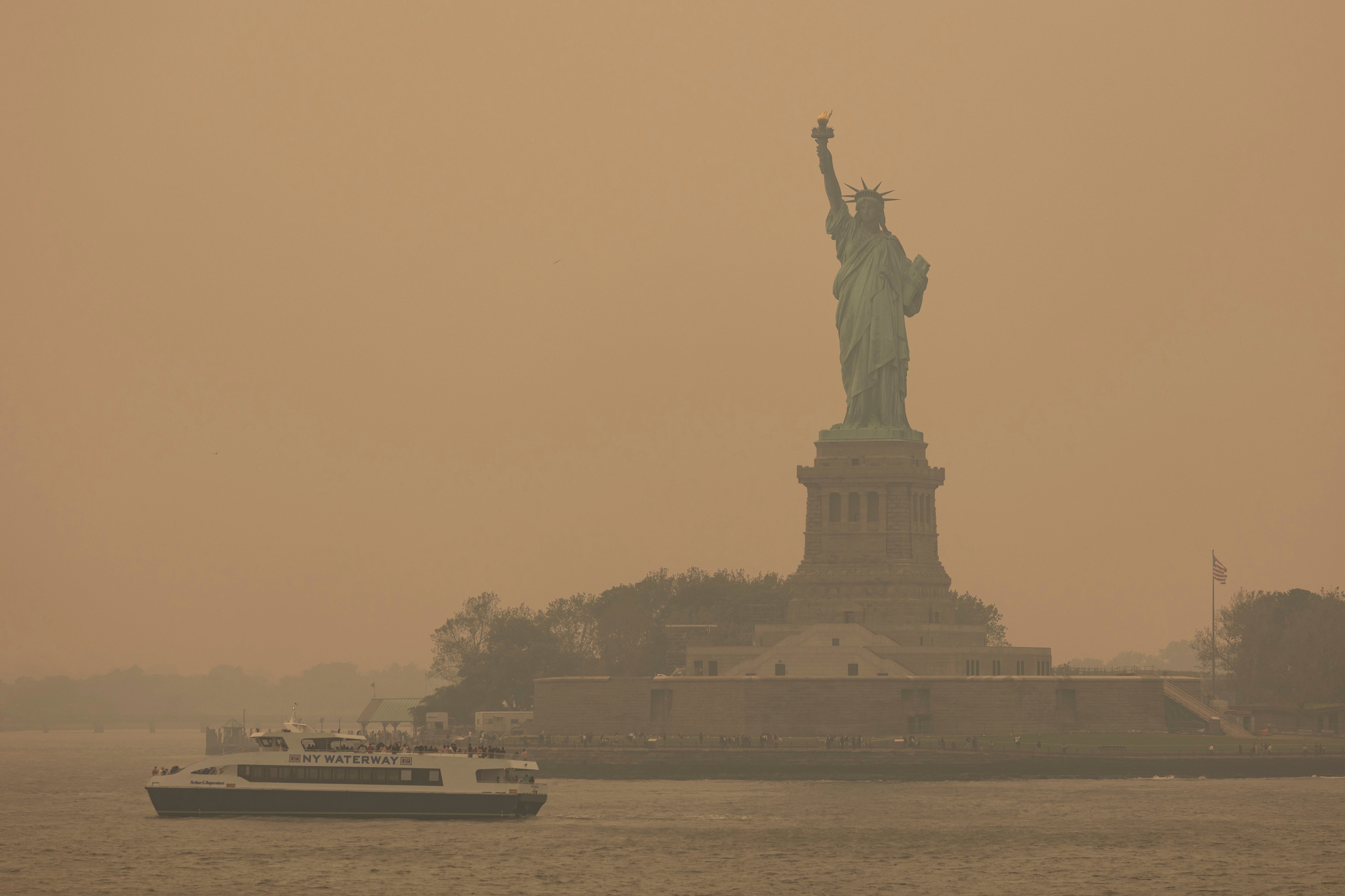 The Statue of Liberty, covered in a haze-filled sky, is photographed from the Staten Island Ferry, Wednesday