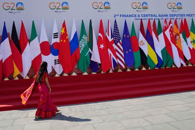 <p>A delegate walks past a display of flags of participating countries at the venue of G20 finance meeting on the outskirts of Bengaluru, India last month </p>