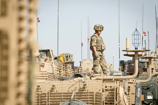 <p>A British soldier stands on top of an armoured vehicle as David Cameron visits Camp Bastion on 29 June 2013 near Lashkar Gah, in Helmand province, Afghanistan</p>