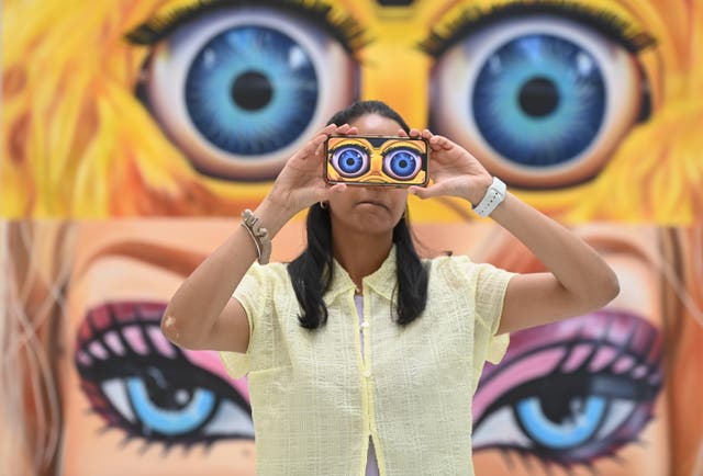 <p>A gallery worker poses with work by artist Rachel Hobkirk during a press preview of The RA Schools Show 2023 at the Royal Academy of Arts in London</p>