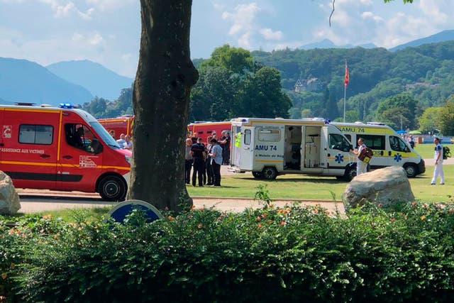Ambulances and rescue trucks are seen after a knife attack in a park of Annecy, French Alps (Florent Pecchio/L’Essor Savoyard via AP)