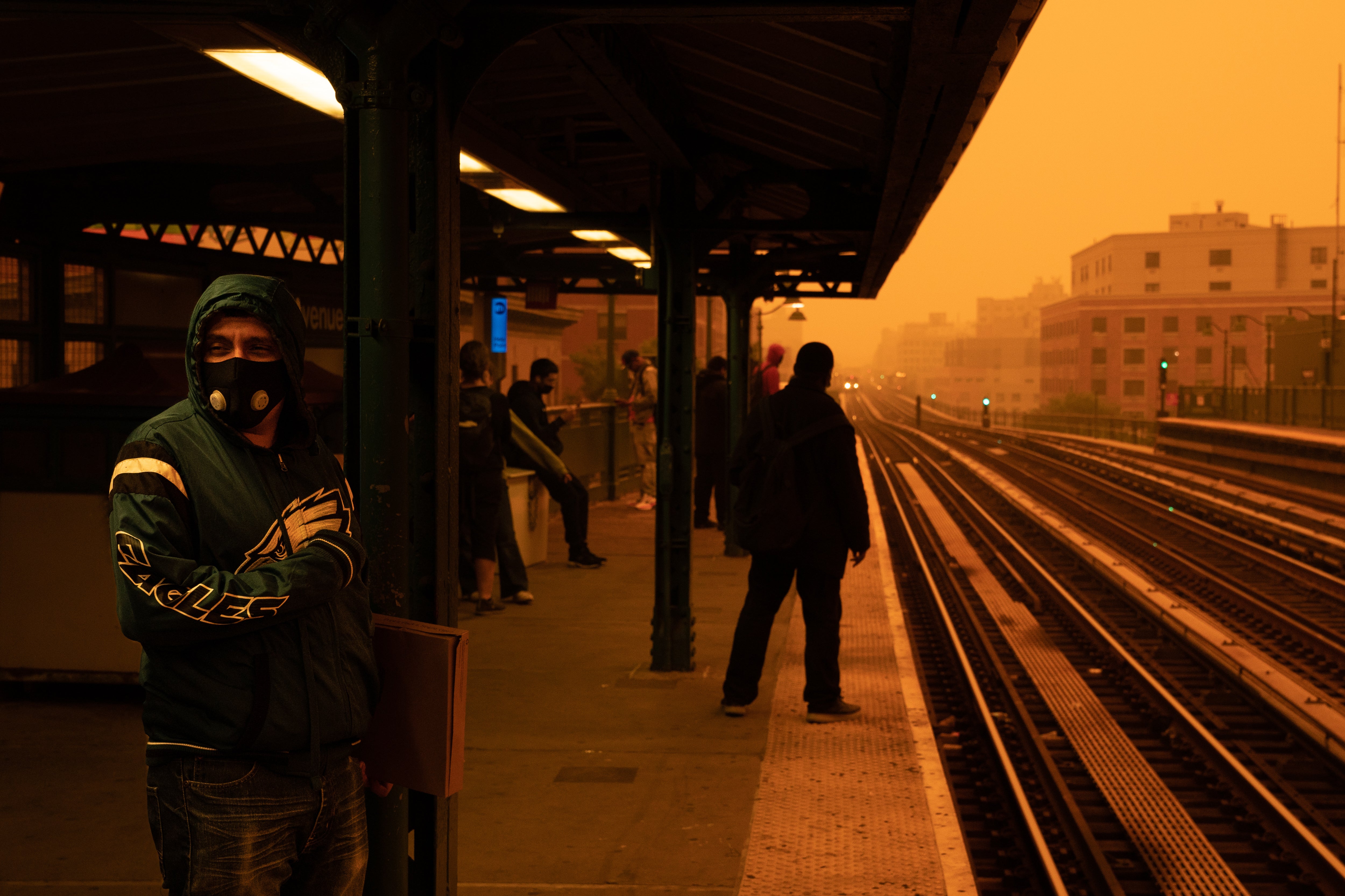 A person waiting for the subway wears a filtered mask as smoky haze from wildfires in Canada blankets a neighborhood on June 7, 2023 in the Bronx, New York City
