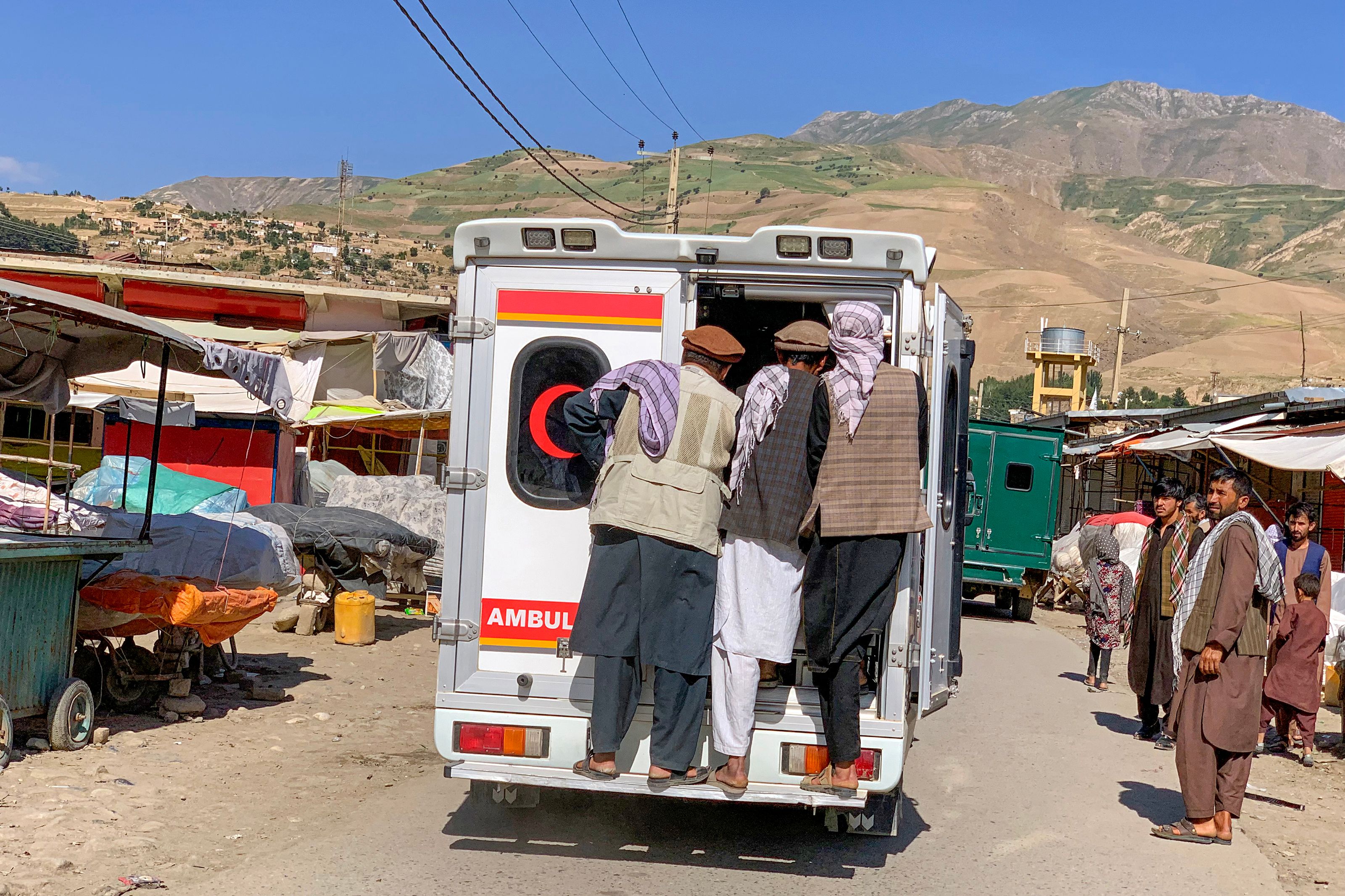 Relatives carry the bodies of slain victims in an ambulance after a bomb explosion during Fatiha prayers at the Nabawi mosque in the Hesa-e-Awal area of Fayzabad district, Badakhshan province