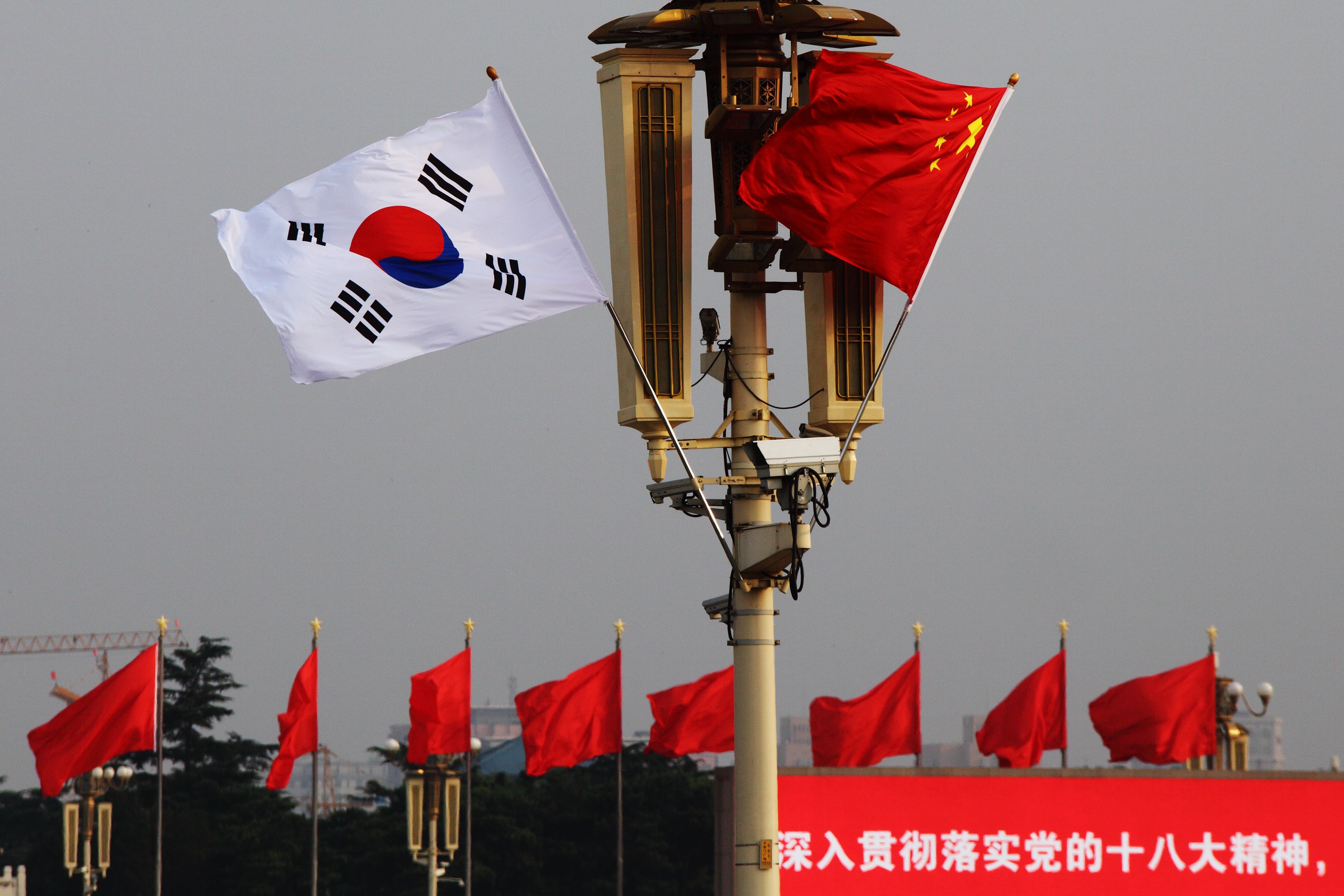 Chinese and South Korean flags flutter in front of Tiananmen Rostrum in Beijing
