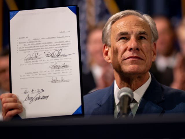 <p>Texas governor Greg Abbott displays a bill he signed at the state Capitol on 8 June 2023 in Austin</p>