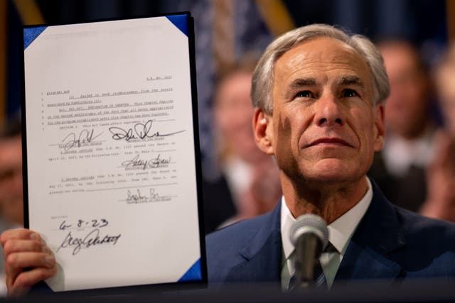 <p>Texas governor Greg Abbott displays a bill he signed at the state Capitol on 8 June 2023 in Austin</p>