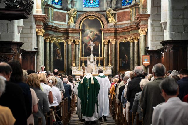 <p>Father Didier Milani (C-L) and Bishop Yves Le Saux (C) arrive for a mass in Annecy on 9 June </p>
