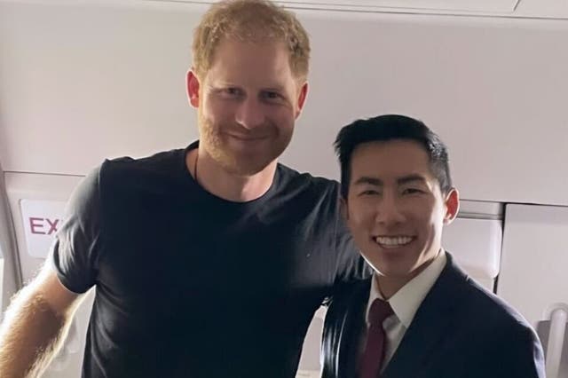 <p>Prince Harry poses for a photograph with American Airlines air steward Holden Pattern</p>