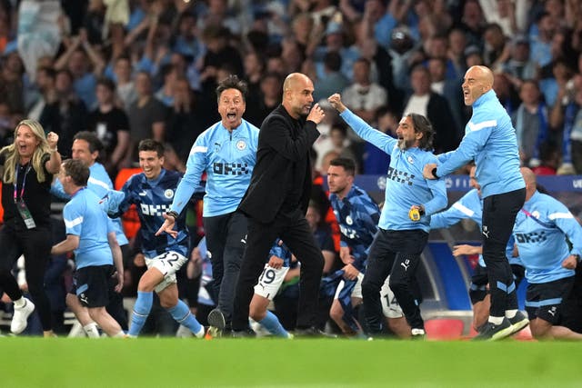 Manchester City manager Pep Guardiola and players celebrate winning the Champions League final (Martin Rickett/PA)