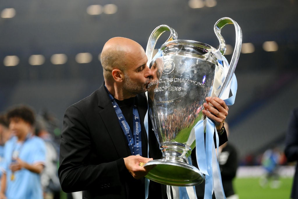 <p>Pep Guardiola gets his hands on the trophy for the third time as a manager </p>