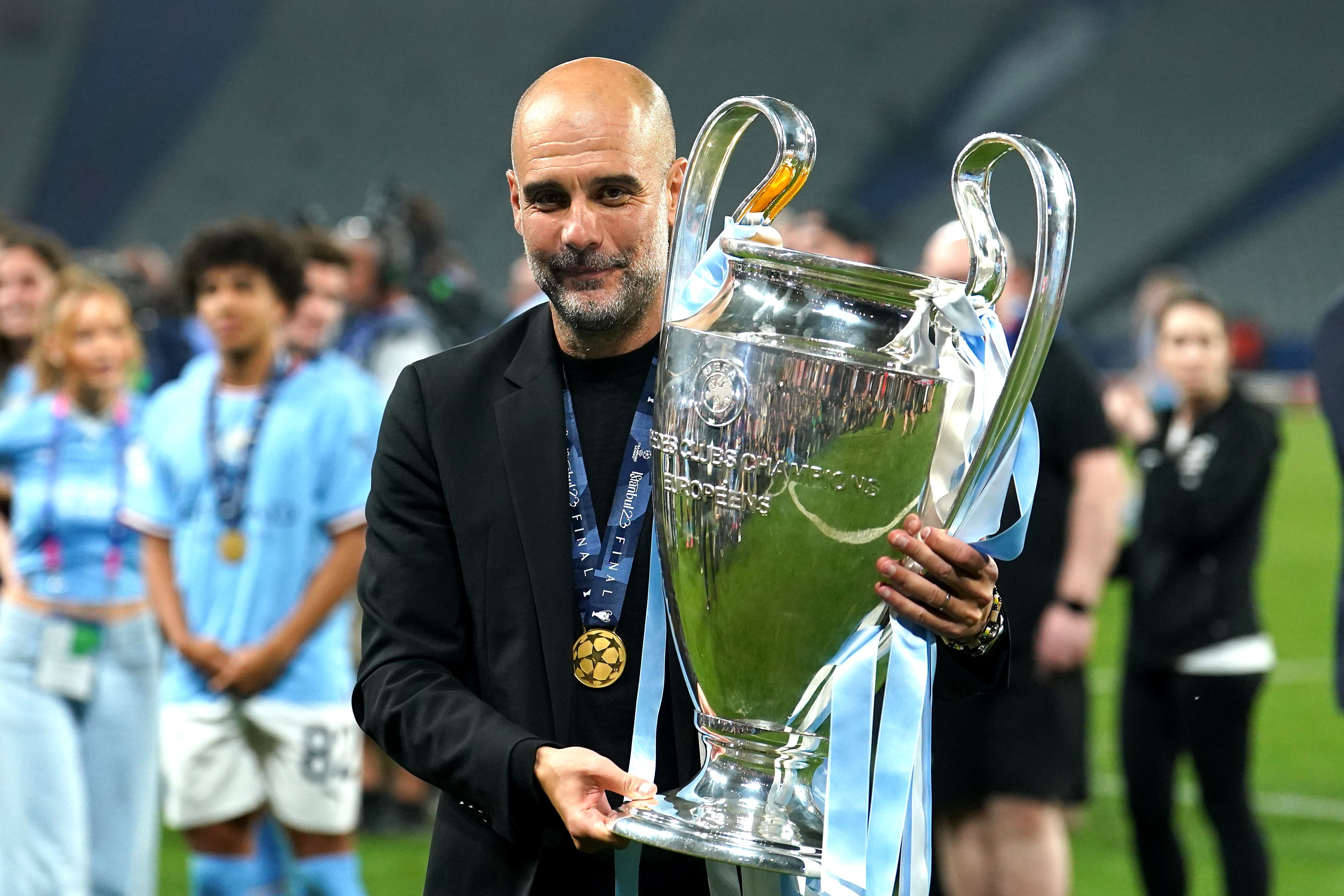  Pep Guardiola celebrates with the Champions League trophy after Manchester City's victory.