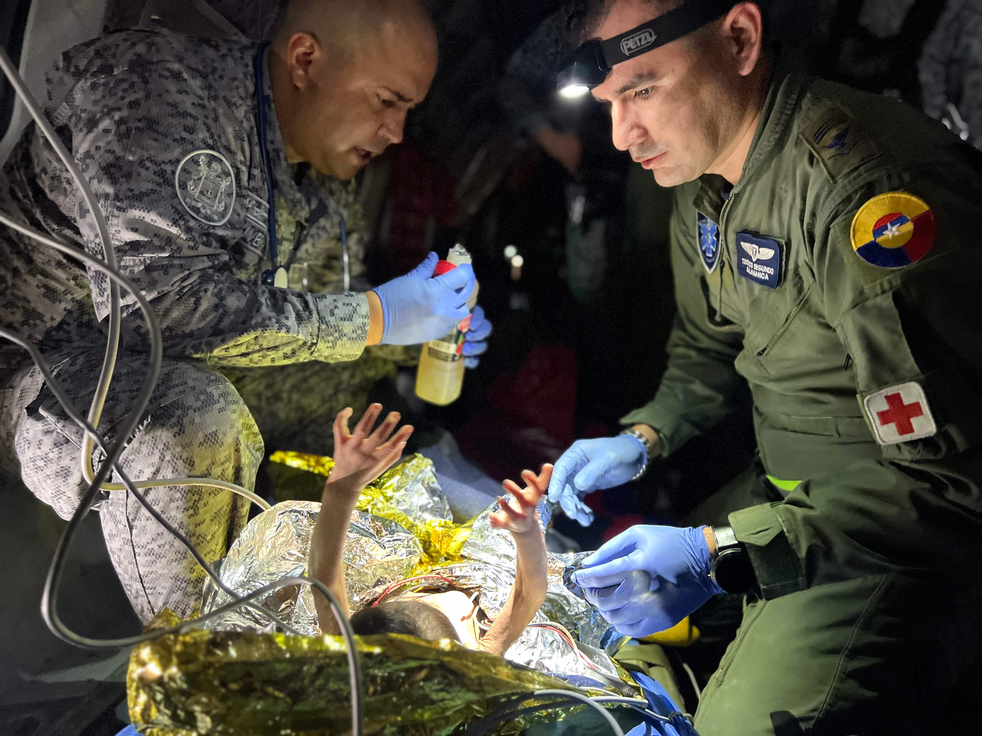 <p>Members of the Colombian Army checking one of the four Indigenous children who were found alive after being lost for 40 days in the Colombian Amazon rainforest </p>