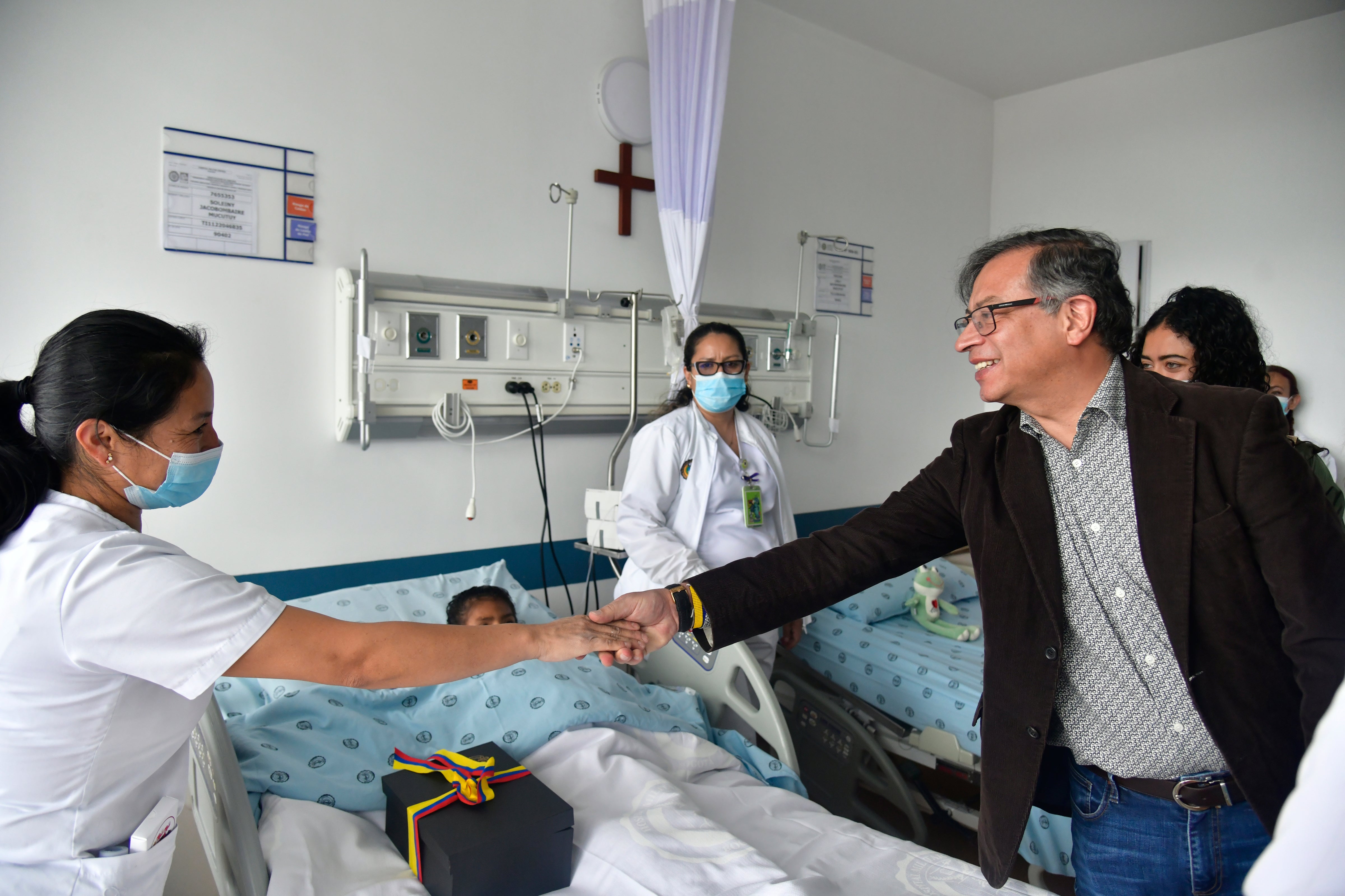 Colombia's President Gustavo Petro greets a nurse tending to one of the four Indigenous children who survived an Amazon plane crash that killed three adults and then braved the jungle for 40 days before being found alive