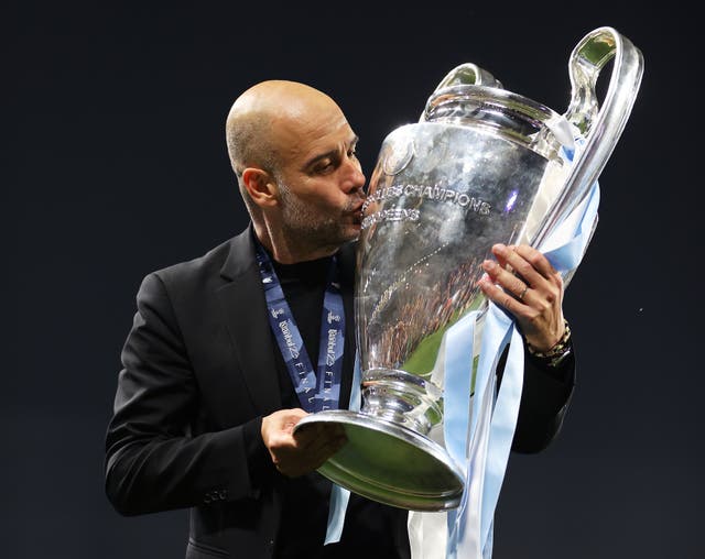 <p>Pep Guardiola celebrates with the Champions League trophy</p>