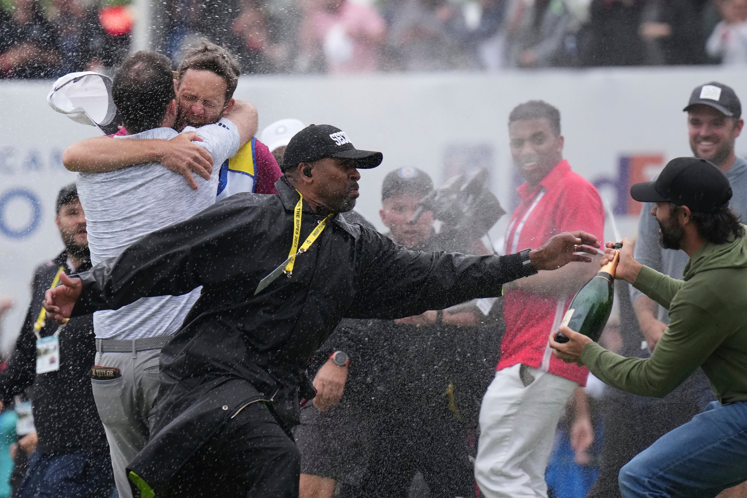 A security moves in to tackle champagne-wielding Adam Hadwin