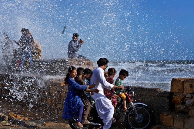 <p>People enjoy high tide waves on the Arabian Sea in Karachi, Pakistan</p>