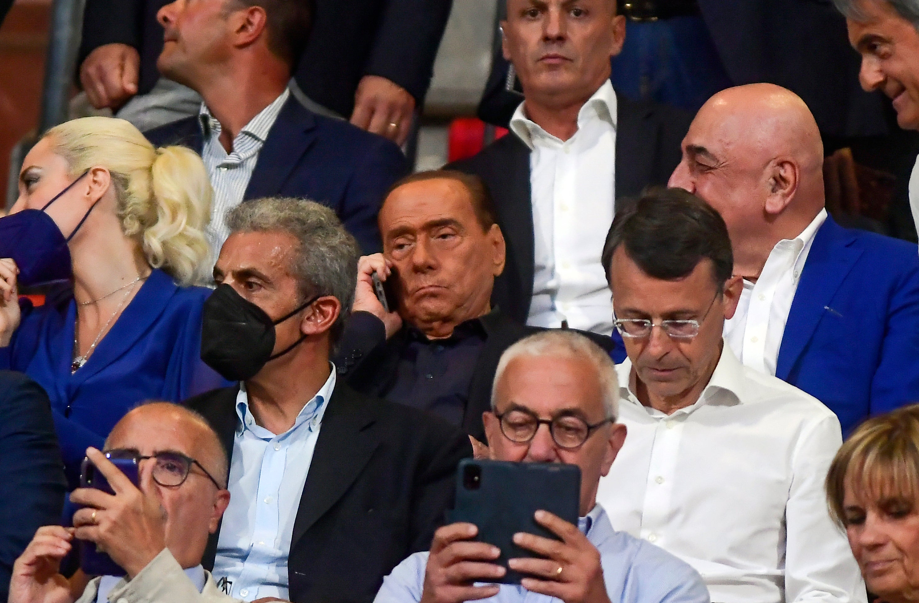 Berlusconi is flanked by Adriano Galliani, partially seen at right, as he talks on his phone during a Serie A football match between Monza and Torino in 2022