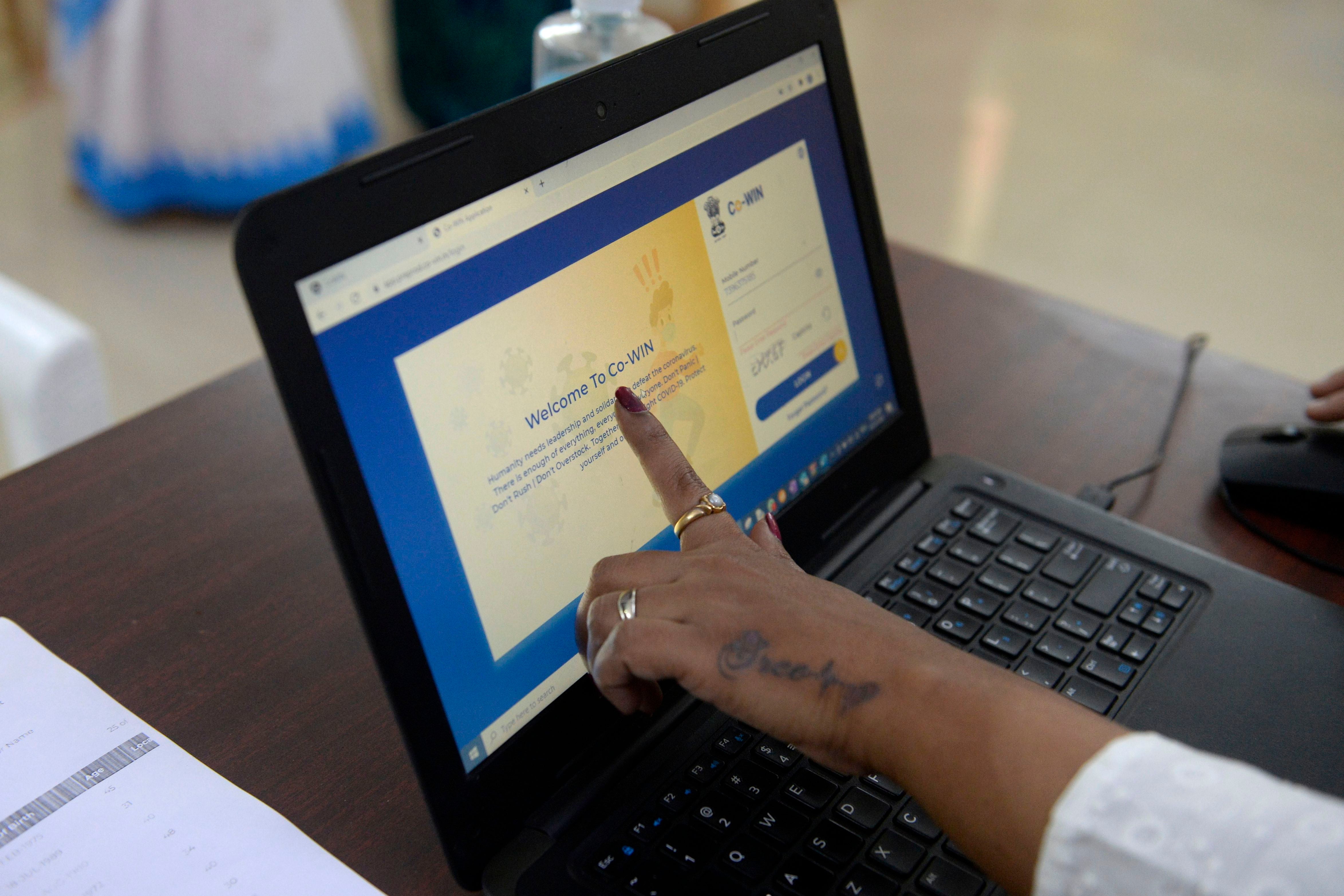 File: A health official shows a CoWIN app to test beneficiaries as she takes part in dry run or a mock drill for Covid-19 coronavirus vaccine delivery